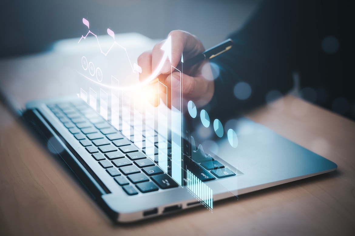 Businessman focused on laptop, analyzing a graph displayed on the screen, indicating data trends and performance metrics