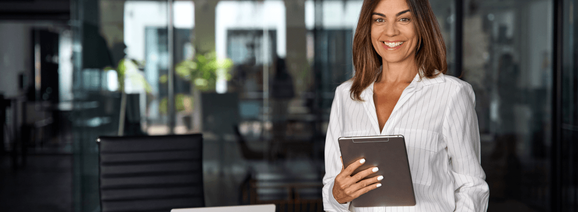 A professional retail professional in a business shirt confidently holds a tablet, ready for her next meeting