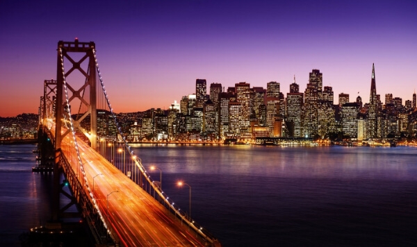 San Francisco skyline illuminated at dusk, showcasing iconic buildings against a colorful twilight sky.