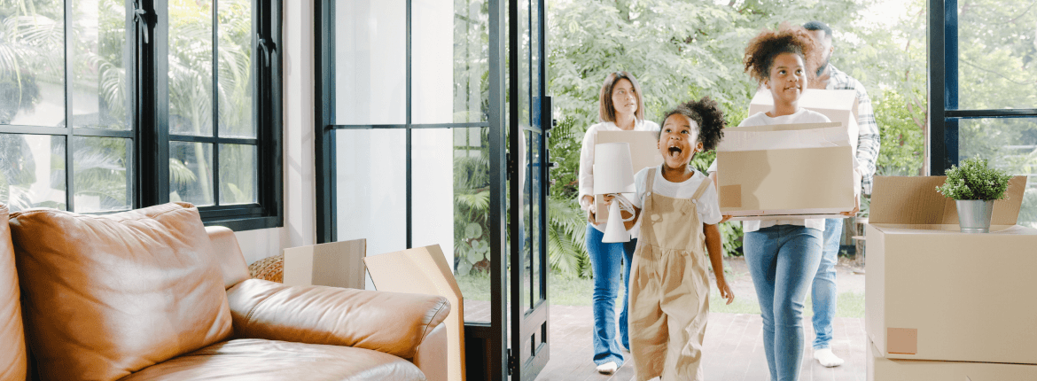 Family moving into a new home with boxes and staring at a new home